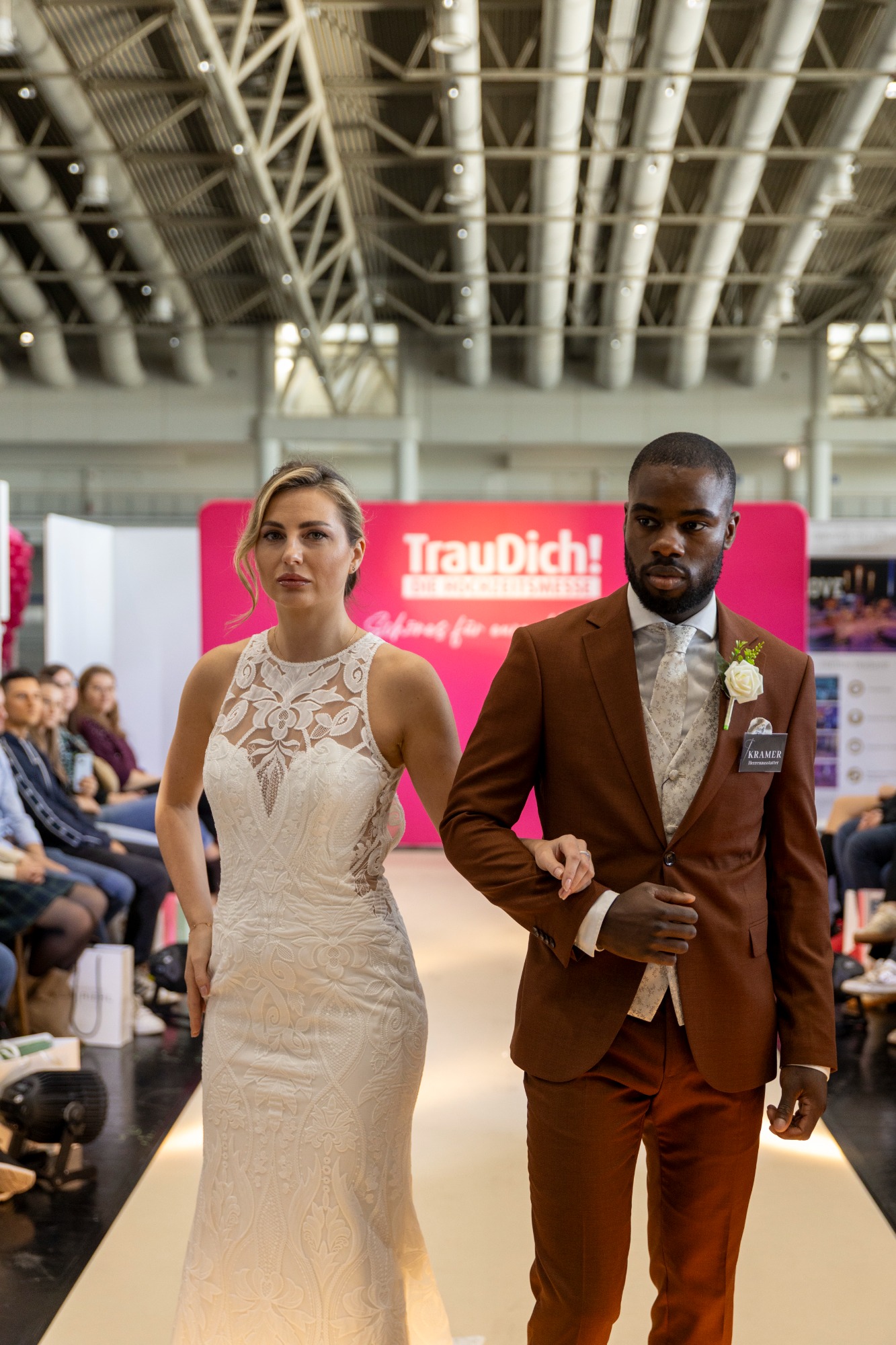 Braut und Bräutigam auf dem Laufsteg in eleganter Hochzeitsmode.